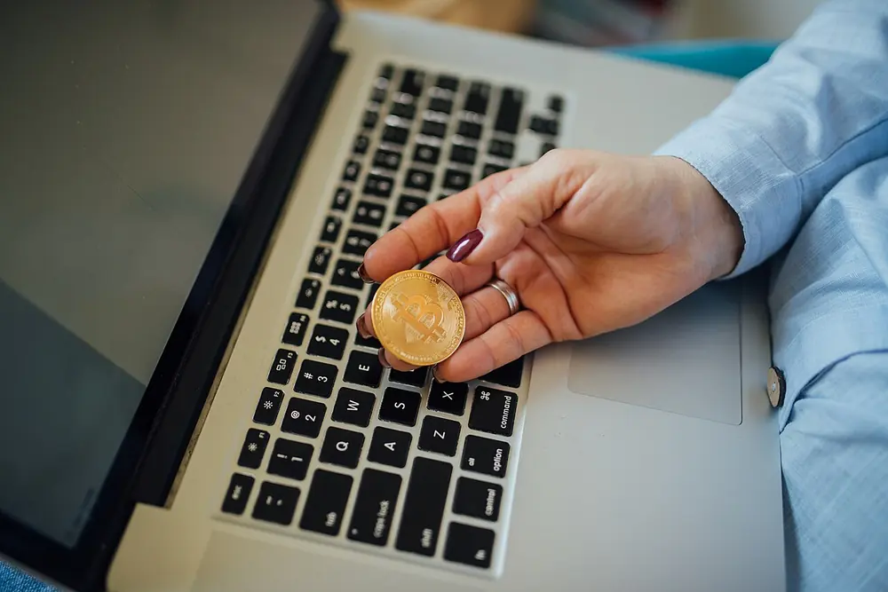 Physical bitcoin coin held in a hand - betus withdrawal time nigeria